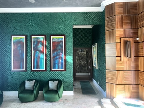 Family room with curved sectional, textured wall finish, and layered art