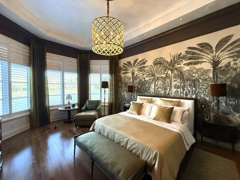 Elegant bedroom with rich wood flooring, tailored drapery, and intimate seating area
