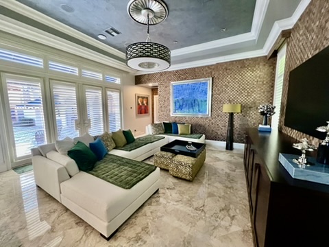 Primary bedroom with mural wallcovering, tailored seating, and layered lighting