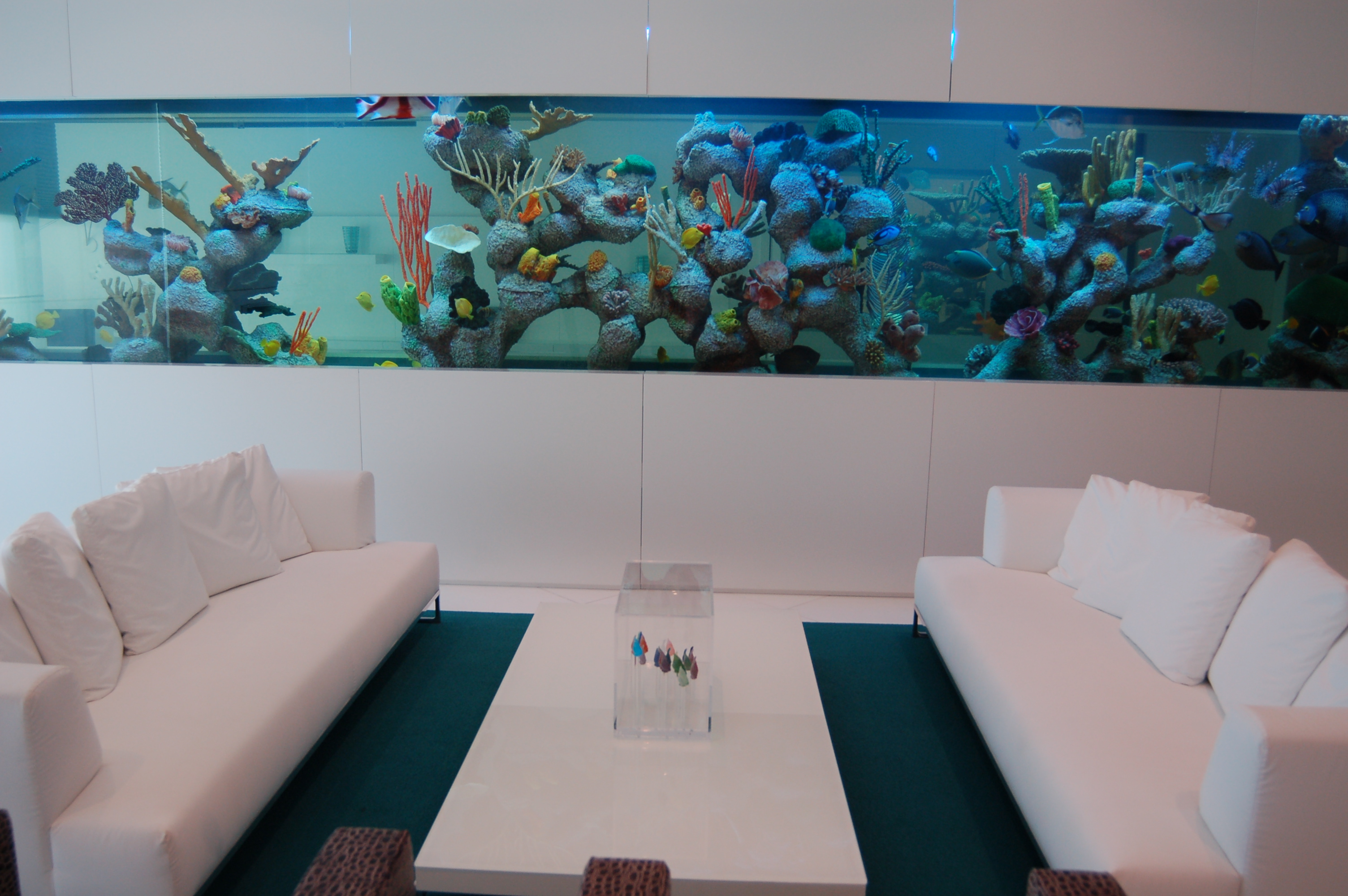 Modern penthouse living space with integrated aquarium wall and minimalist seating