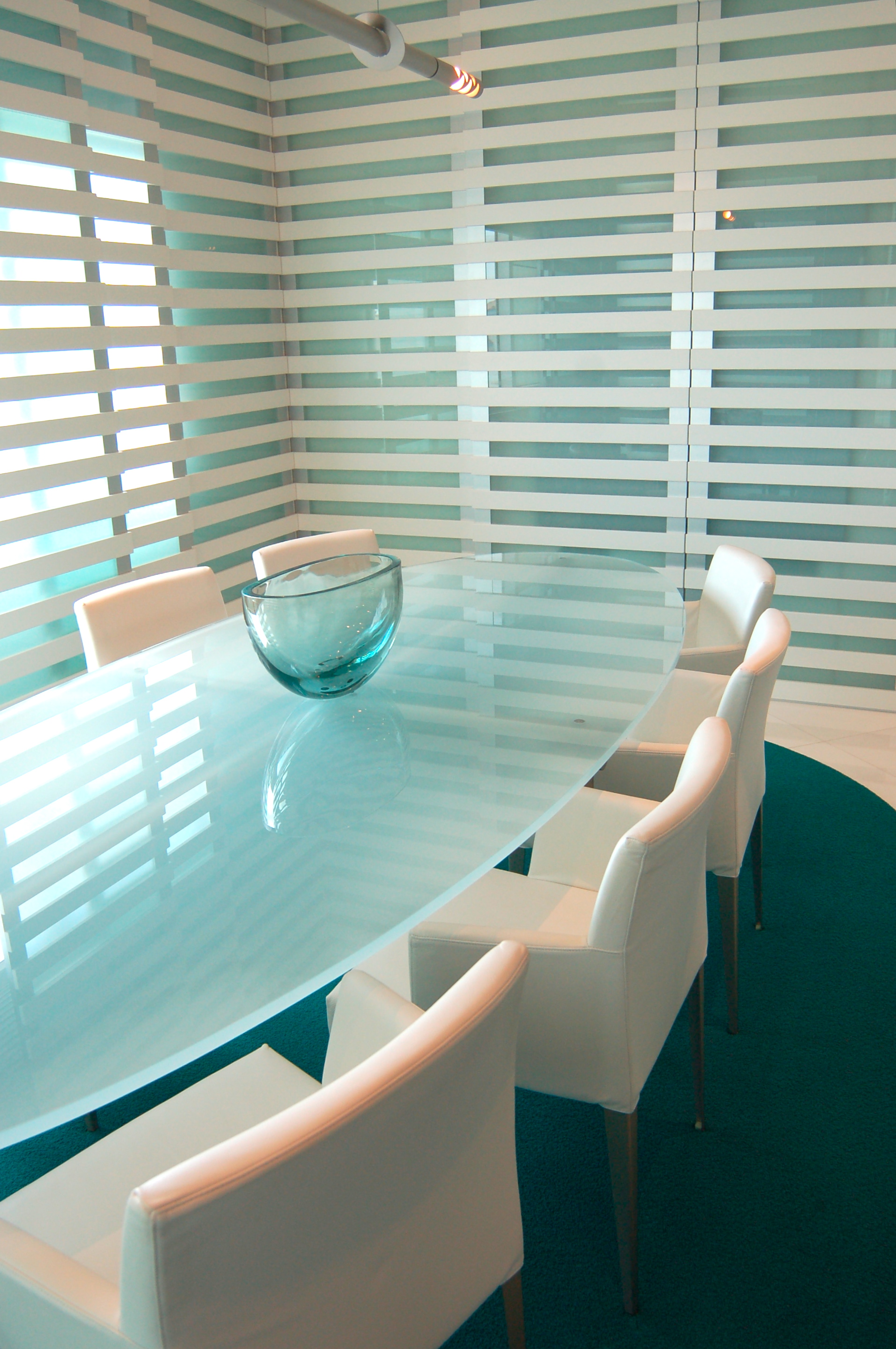 Modern dining space with glass table and structured linear wall design