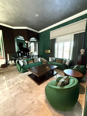 Interior hall with deep green wall treatment, framed art, and wood door leading toward the main rooms