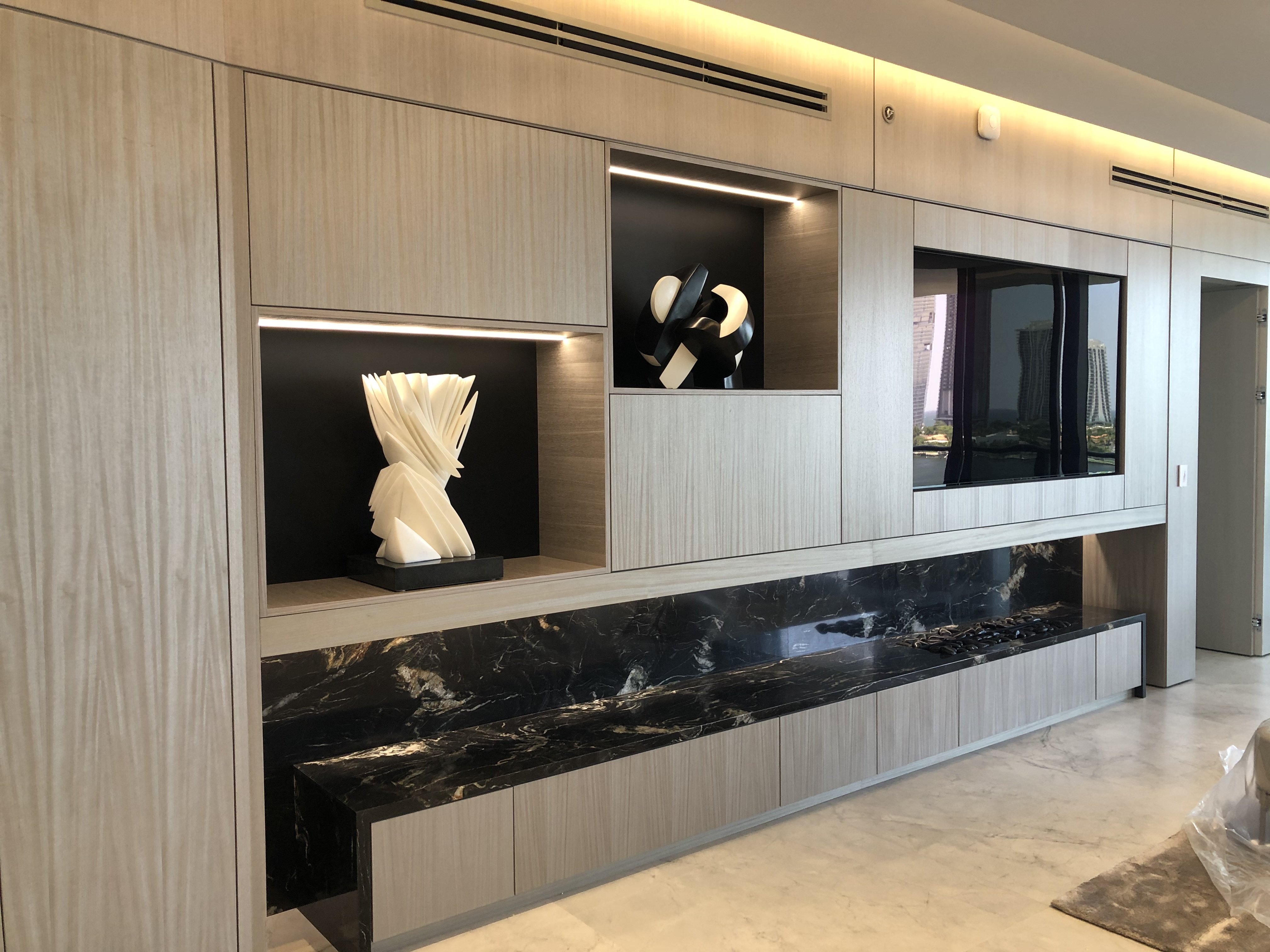 Glass dining table with quilted white chairs in a modern penthouse