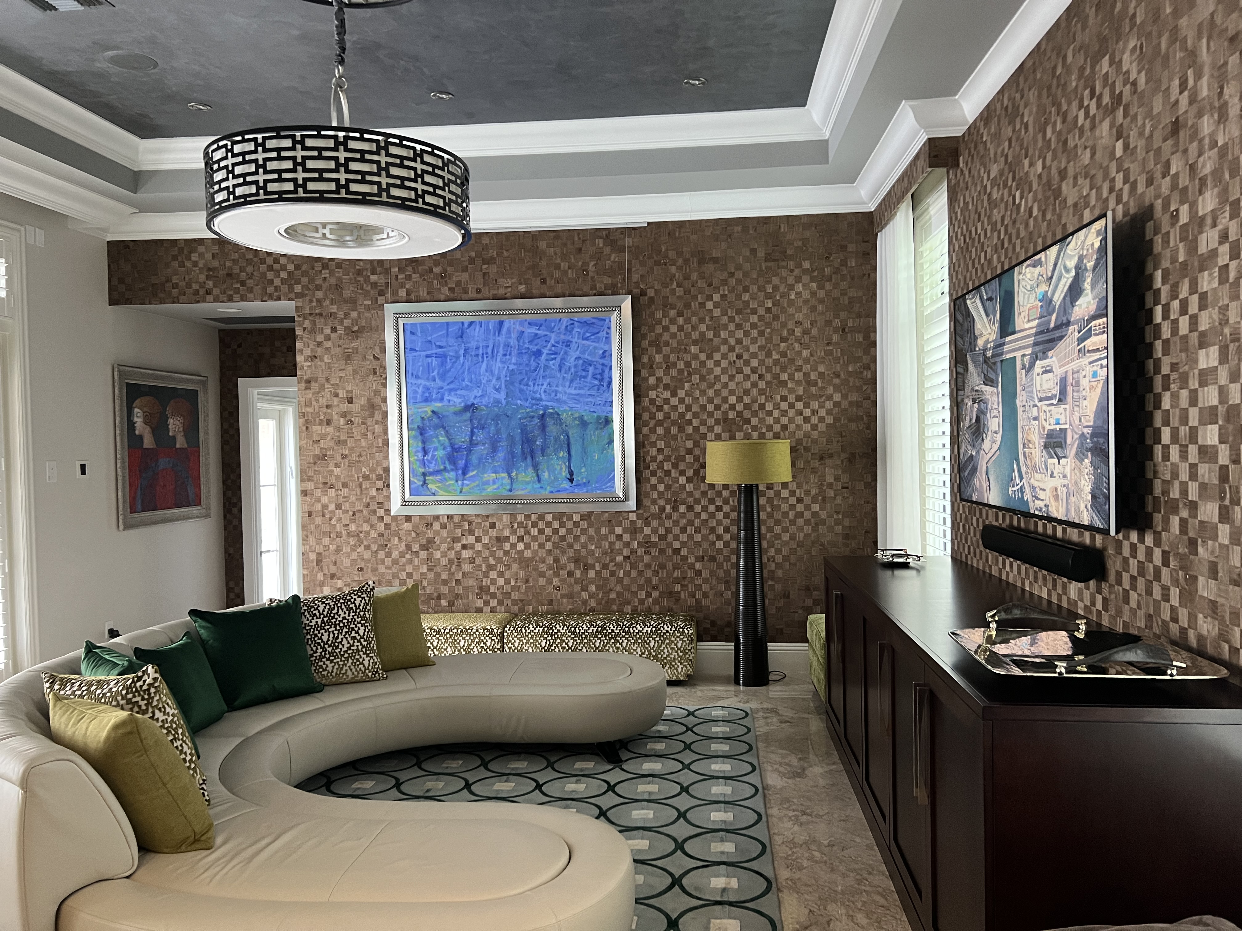 Alternate family room perspective with curved seating, console, and graphic rug