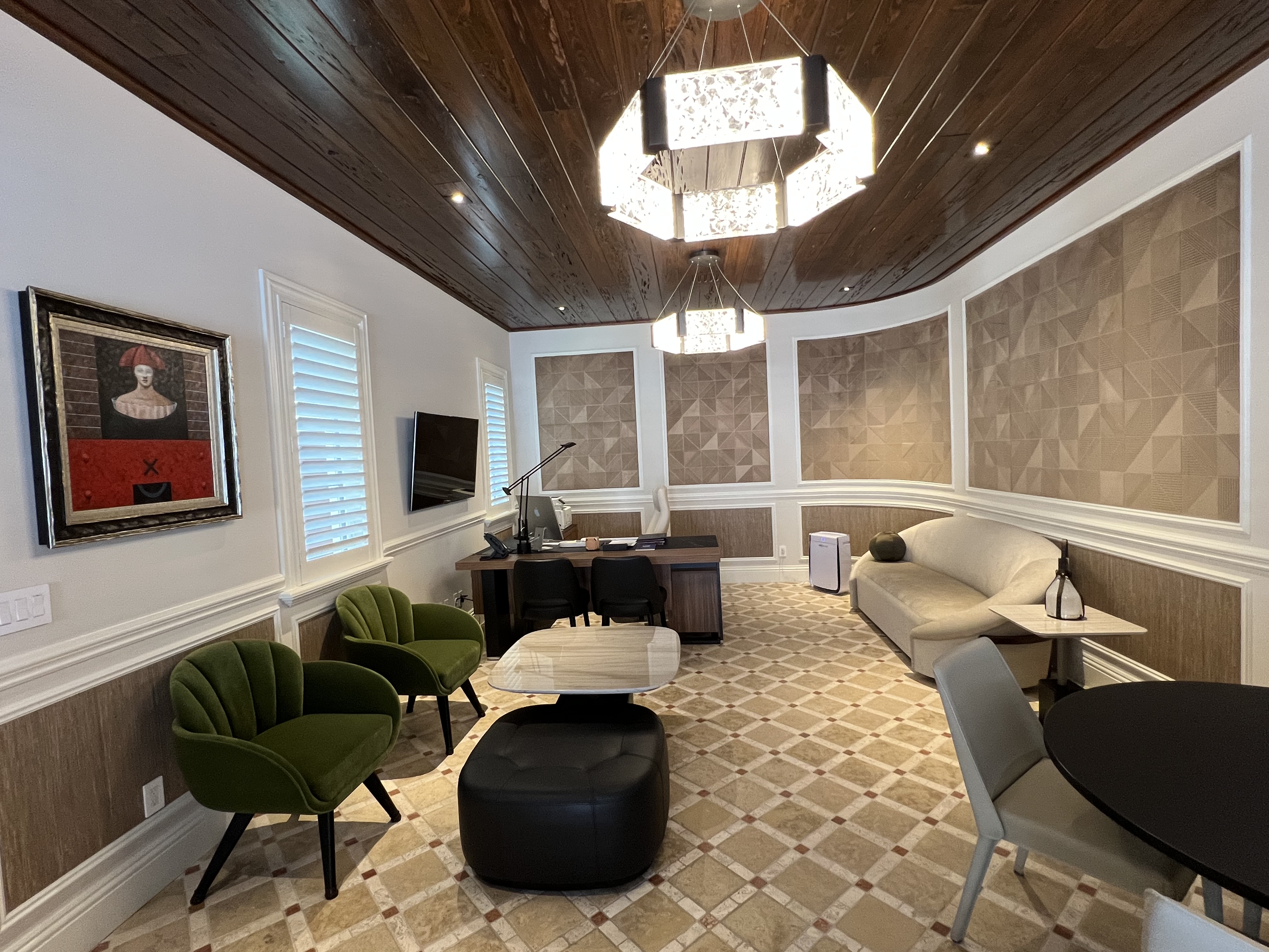 Executive home office with wood ceiling, sculptural lighting, green lounge chairs, and custom wall detailing