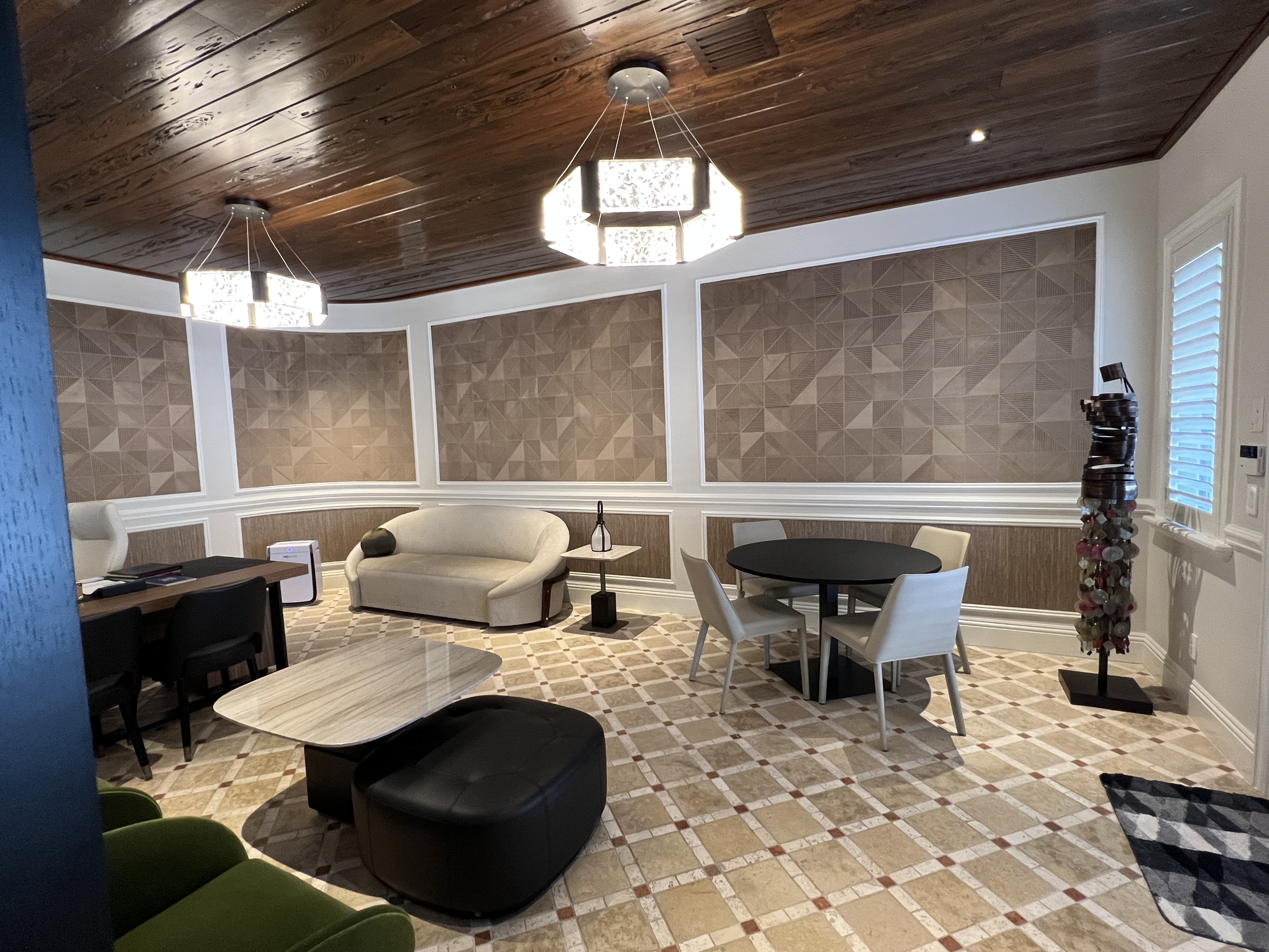 Alternate view of the executive office with conversation table, curved sofa, and wood ceiling