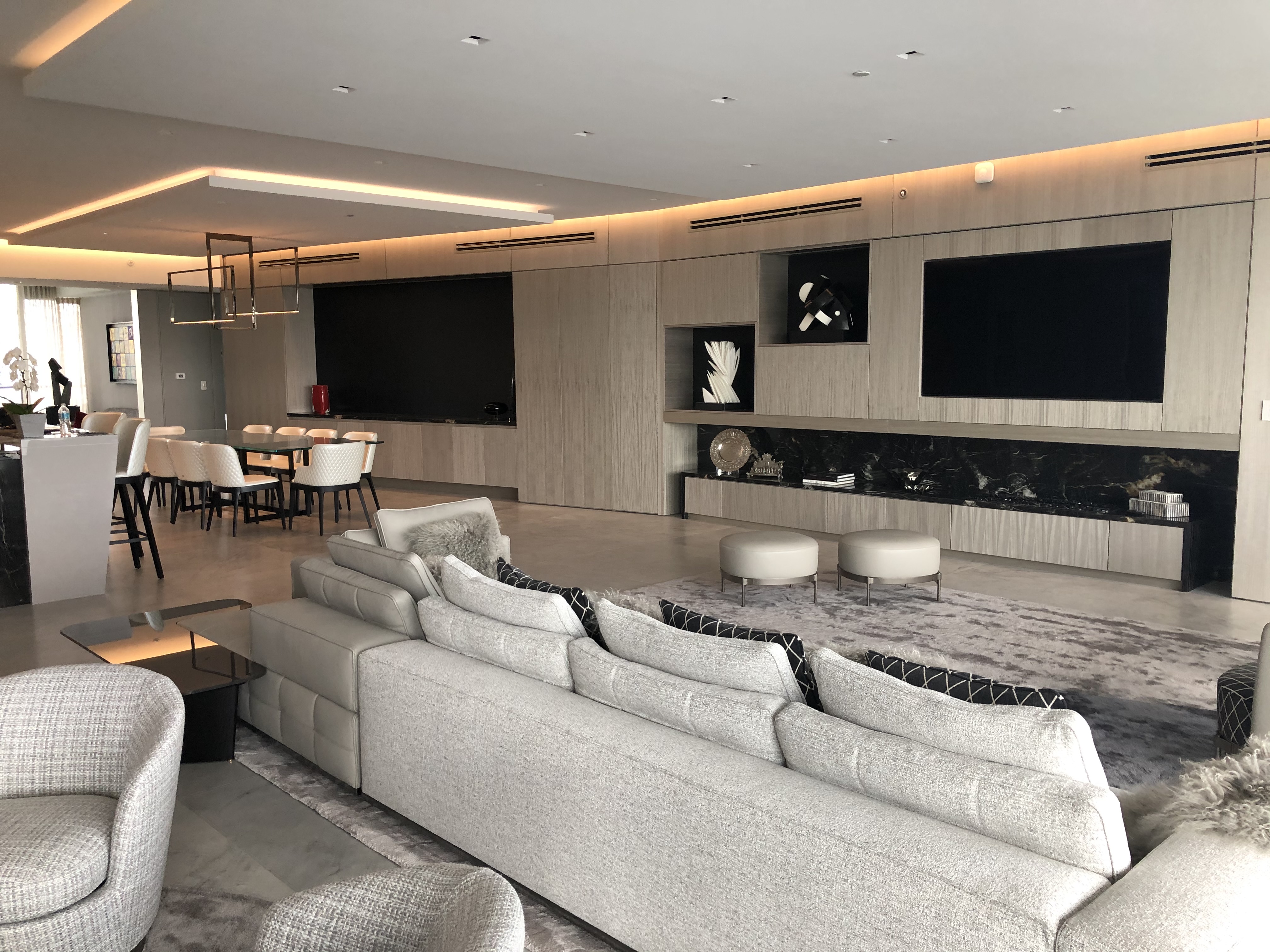 Wide view of penthouse living area, dining, and integrated wall system