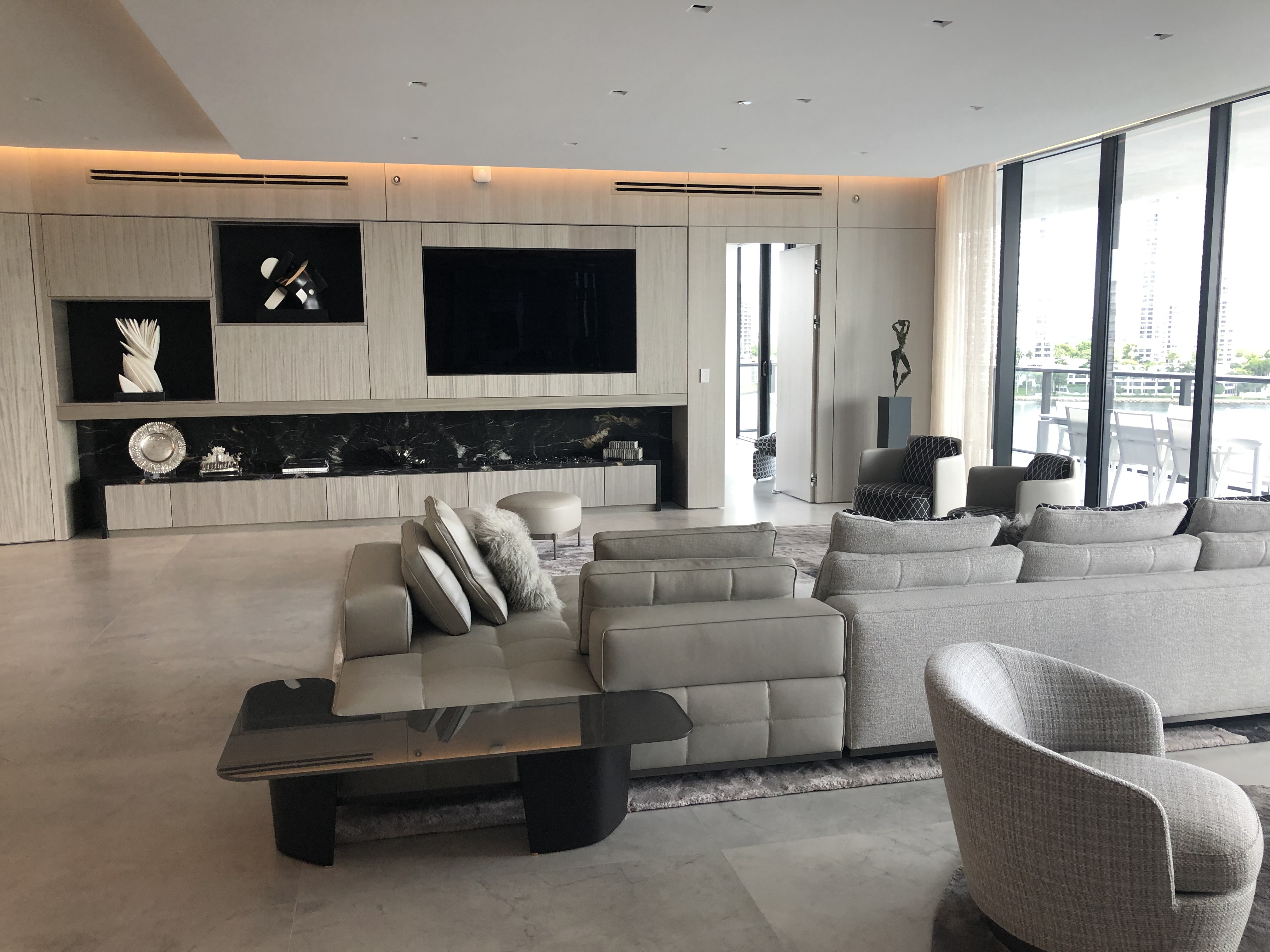Modern penthouse living room with integrated entertainment wall and soft neutral seating