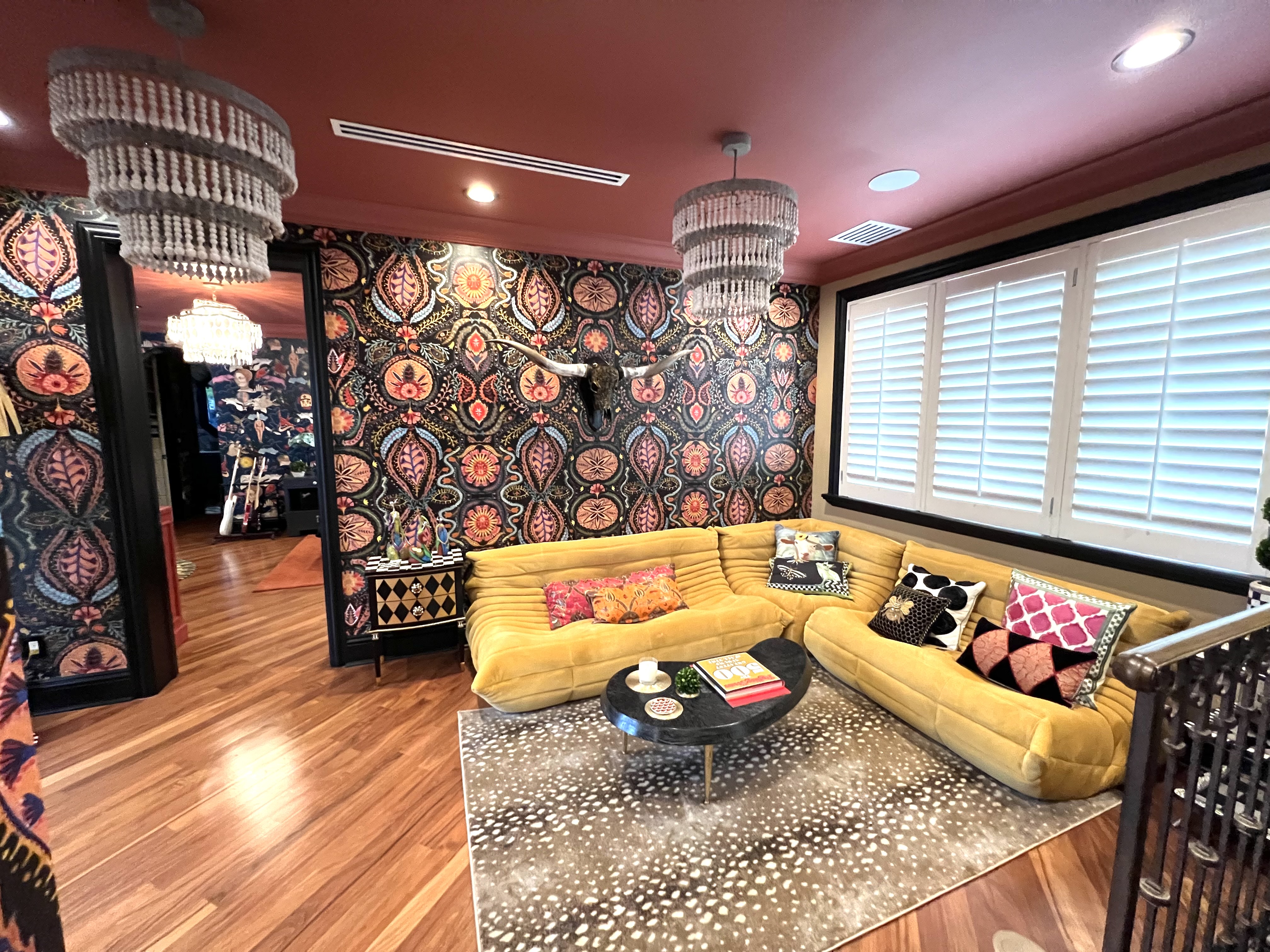 Maximalist daughter’s lounge with patterned wallpaper, coral ceiling, and sculptural yellow seating