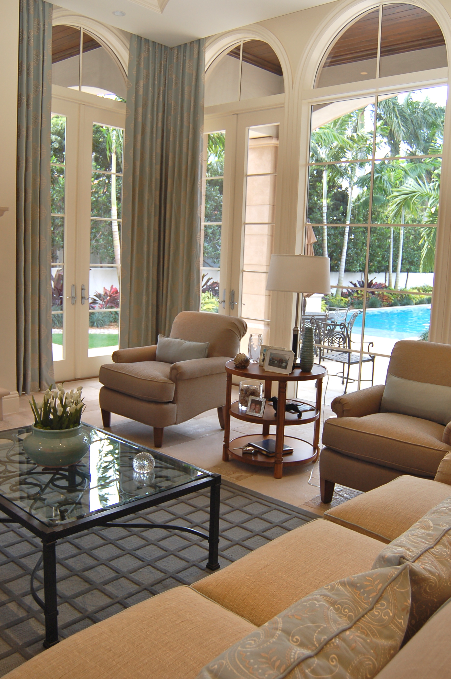 Living room with tall arched windows, soft furnishings, and garden view