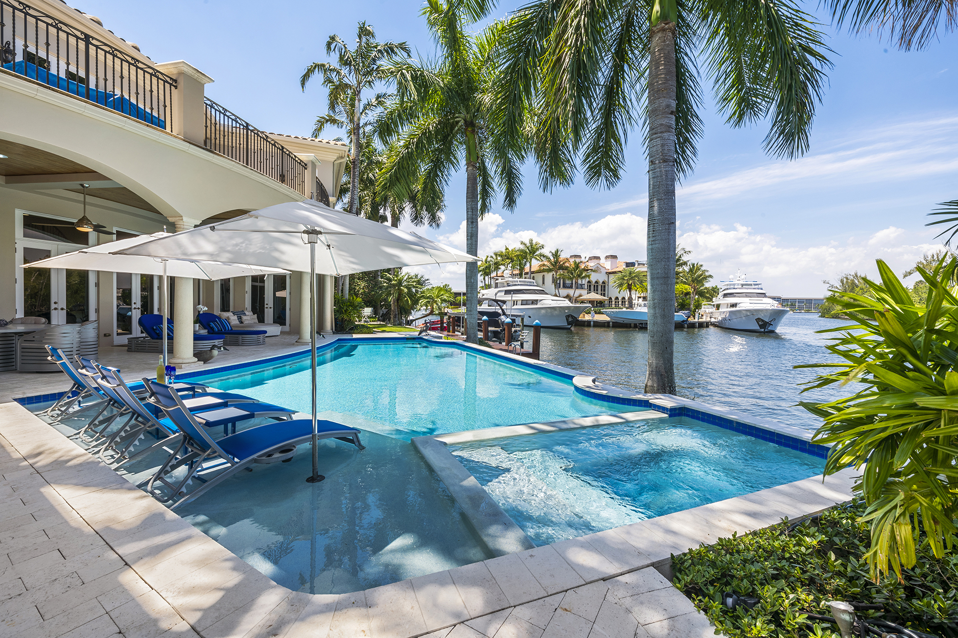 Pool and waterfront view with yachts beyond
